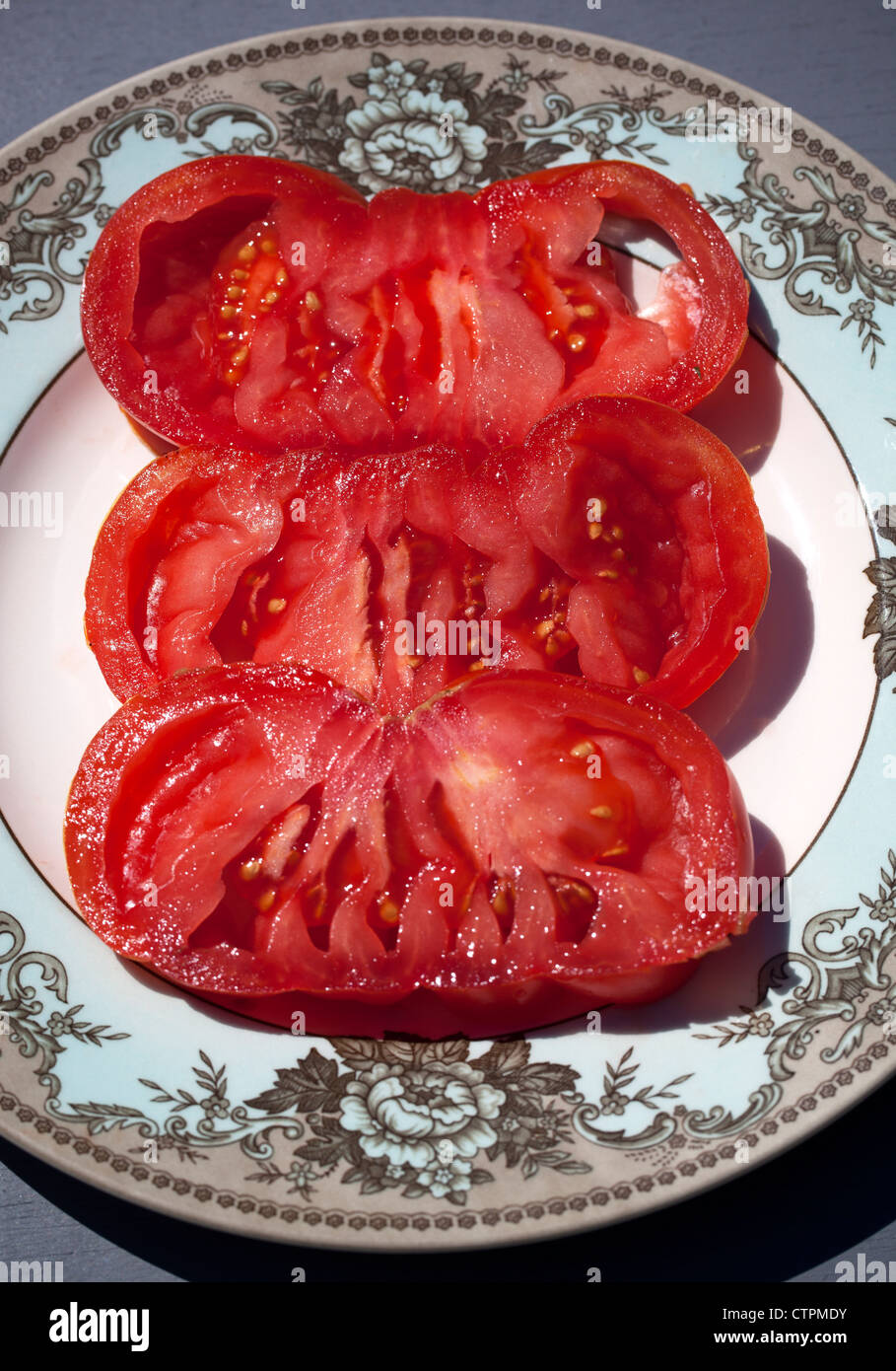 Tranches de Tomates Rose géant (Zapotec Pleated) sur la plaque Banque D'Images