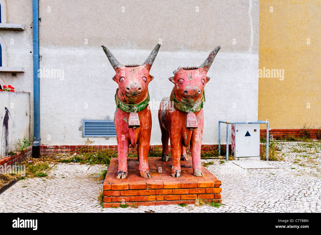 Deux statues en terre cuite de la détérioration des taureaux primitive sur un socle en brique rouge dans un jardin négligé, Santa Maria de Belém, Lisbonne Banque D'Images