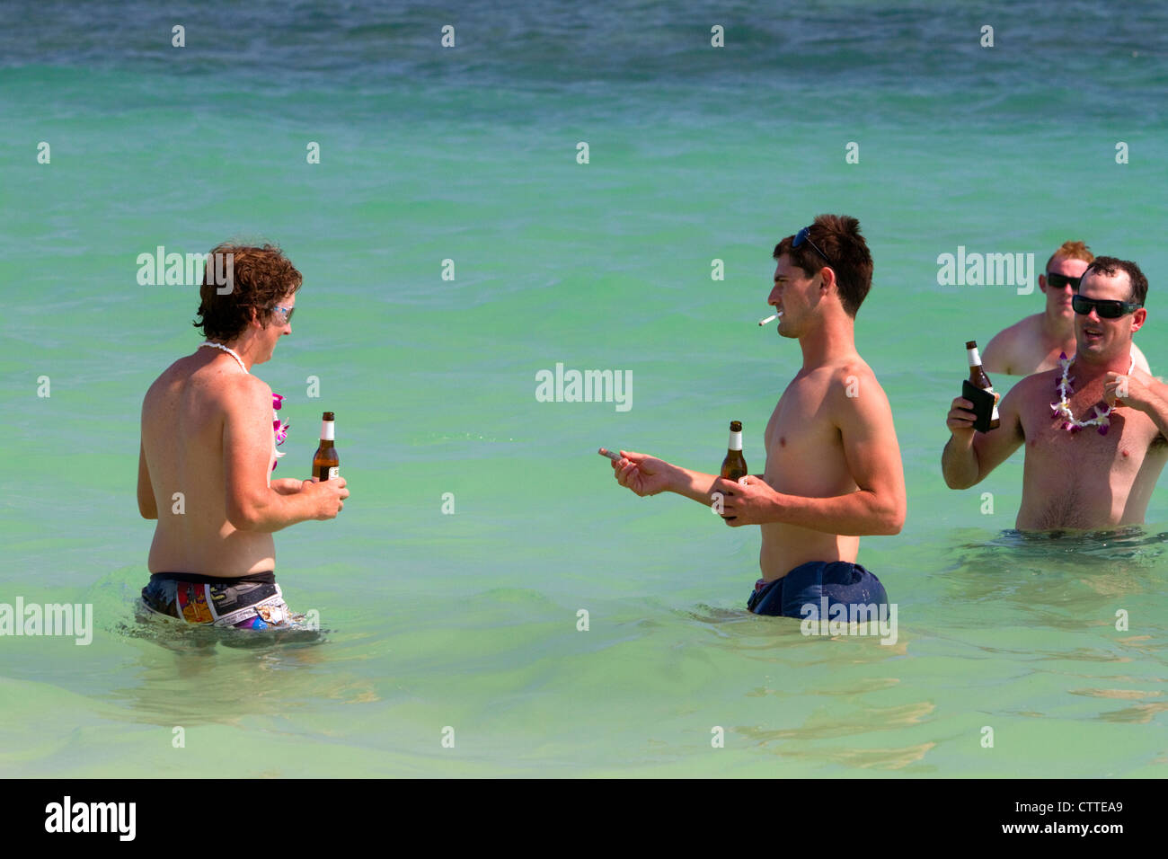 Les gens boivent de la bière en bouteille dans le golfe de Thaïlande à Chaweng Beach sur l'île de Ko Samui, Thaïlande. Banque D'Images