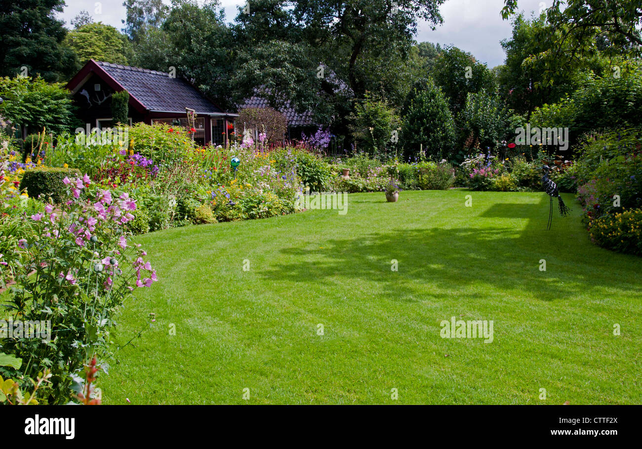 Maison avec jardin à l'anglaise et l'herbe verte Banque D'Images