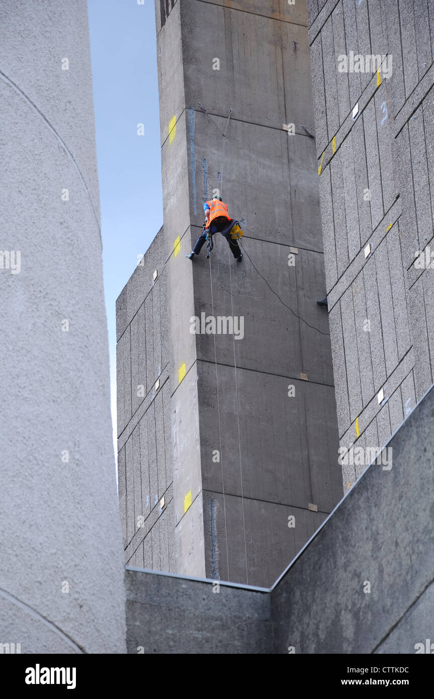 L'homme travaillant en hauteur sur un édifice en hauteur. La bibliothèque de l'Université de Glasgow et reclad programme de modernisation. Banque D'Images