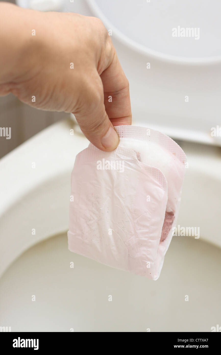 Disposer les mesures sanitaires pad dans la cuvette des toilettes Banque D'Images