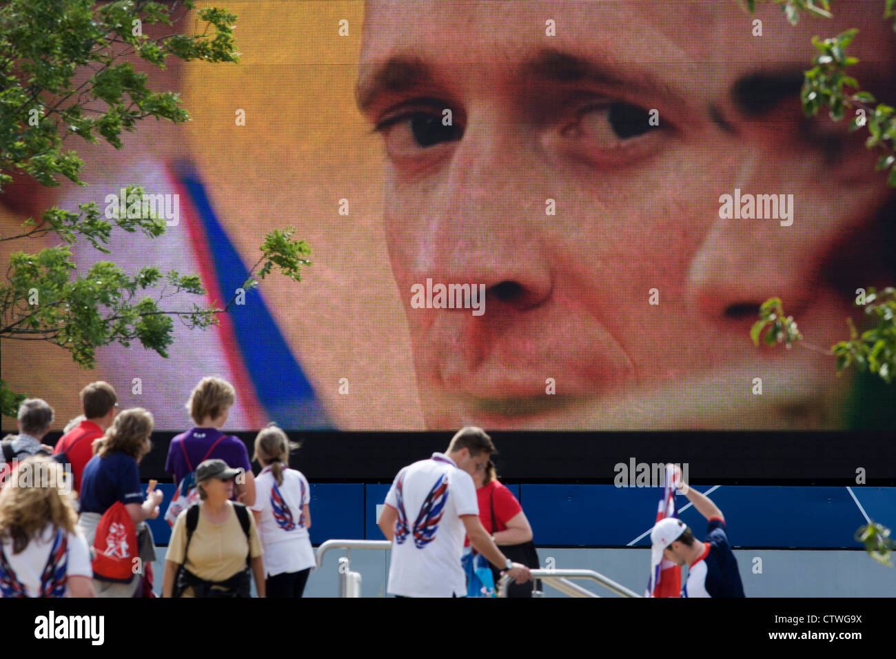 Close-up de l'équipe Go champion cycliste olympique Bradley Wiggins sur un grand écran de télévision au cours de l'Jeux olympiques de 2012 à Londres. Wiggins est devenu un héros pour les Britanniques avec 'Wiggo'' de la victoire dans l'épreuve le jour précédent. Ce terrain a été transformé pour devenir un 2,5 Km2 complexe sportif, une fois que les entreprises industrielles et maintenant le lieu de huit salles dont l'arène principale, centre aquatique et le vélodrome et le Village Olympique des athlètes. Après les Jeux Olympiques, le parc est d'être connu sous le nom de Queen Elizabeth Olympic Park. Banque D'Images