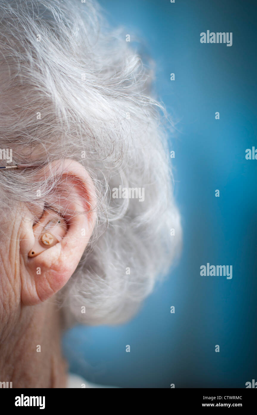 L'aide auditive sur une femme âgée. Banque D'Images