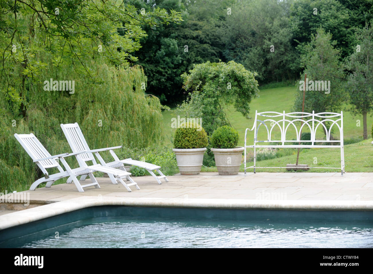 Une piscine et des chaises longues dans le jardin d'un pays UK Banque D'Images