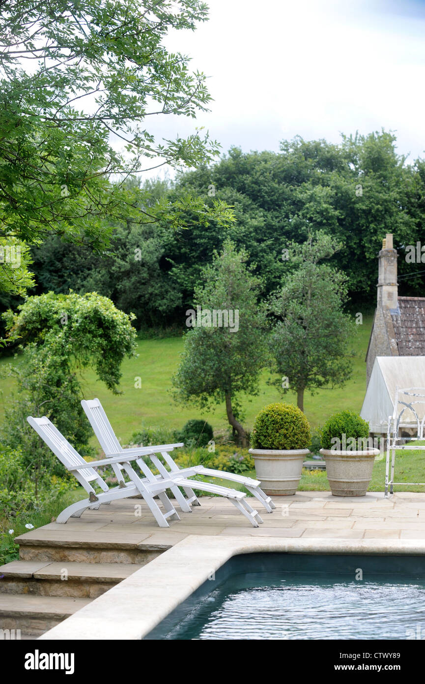 Un Cotswold cottage avec piscine et chaises longues UK Banque D'Images