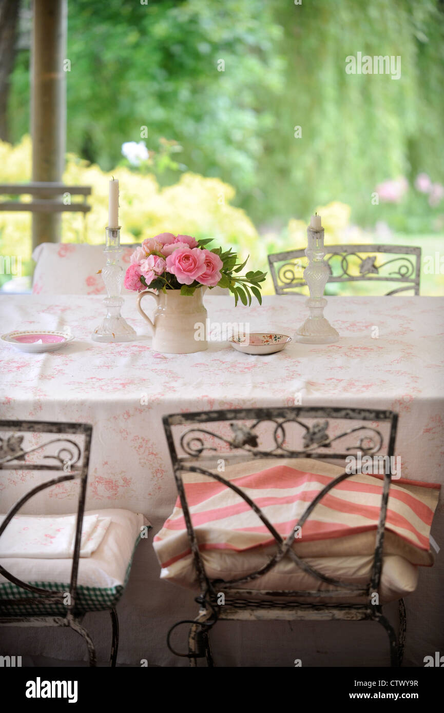 Les chandeliers en verre rose et roses sur une table UK Banque D'Images