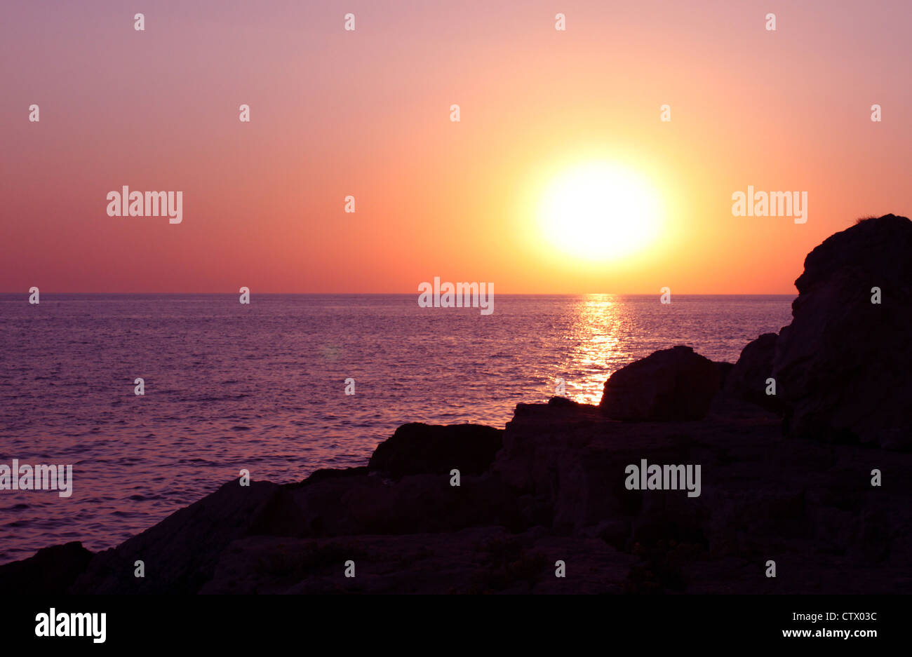 Rochers bord de mer coucher de soleil Banque de photographies et d