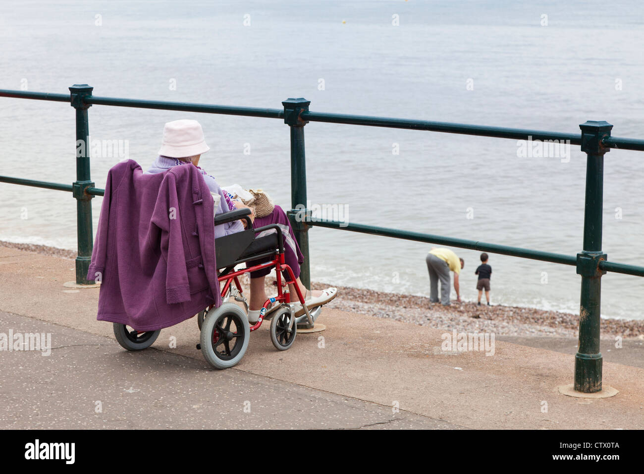 Une vieille dame en fauteuil roulant sur le front de mer de Sidmouth, Devon, UK Banque D'Images