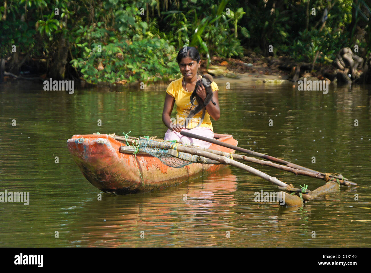 Fille avec monkey en outrigger bateau, rivière Maduwa, Sri Lanka Banque D'Images