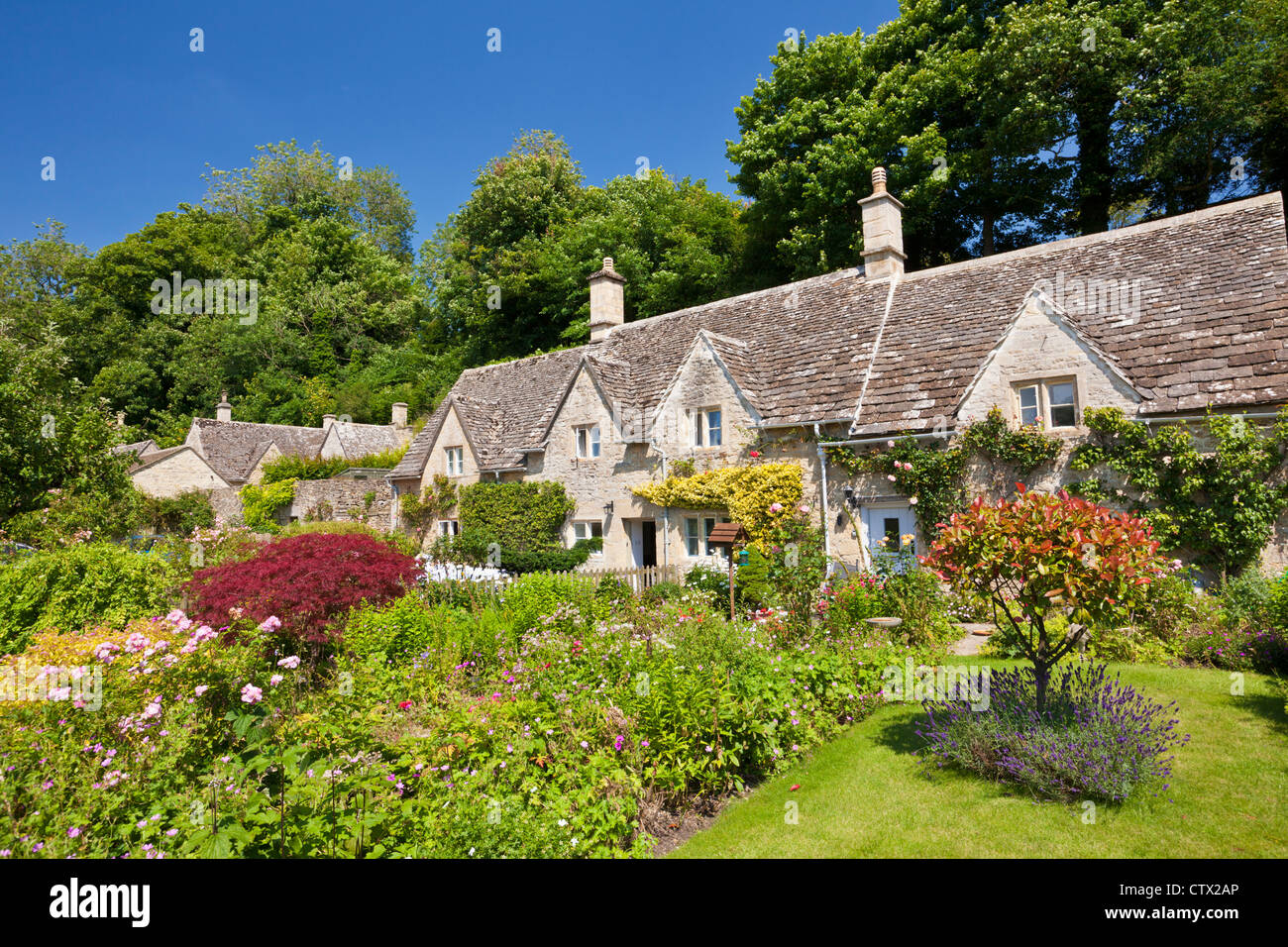 Jolis cottages traditionnels et jardins fleuris dans le pittoresque village des Cotswolds de Bibury Gloucestershire Angleterre GB Europe Banque D'Images