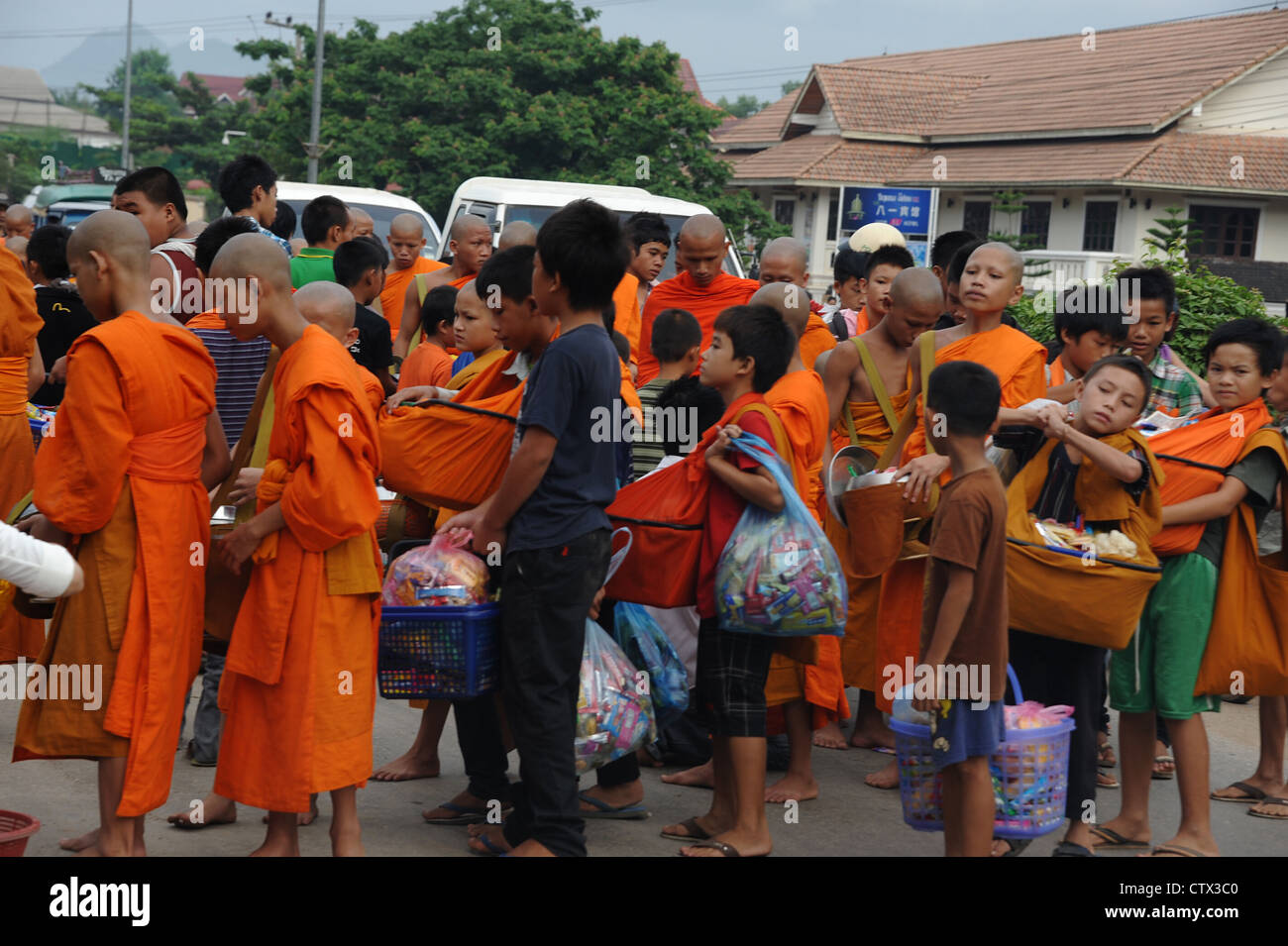 Les moines bouddhistes, la collecte de l'aumône pendant le Carême. Luang Brabang. Banque D'Images