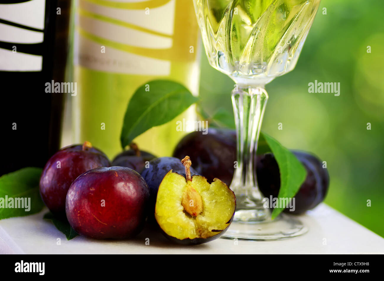 Des bouteilles de vin et de prunes sur la table Banque D'Images