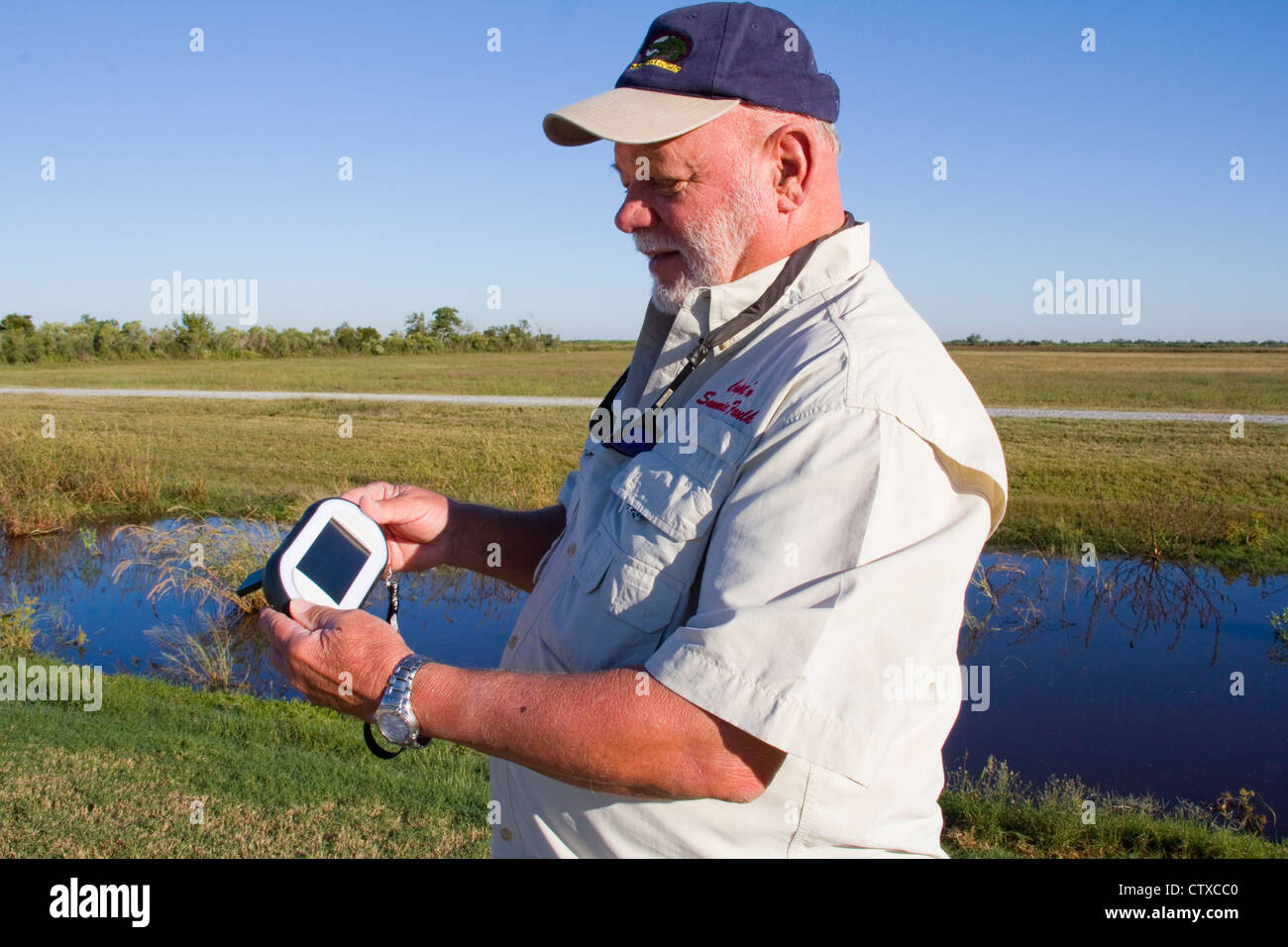 Guide Local Sam Faulk démontre un GPS de poche Ranger video tour appareil, Creole Nature Trail/All-American Road, LA, USA Banque D'Images