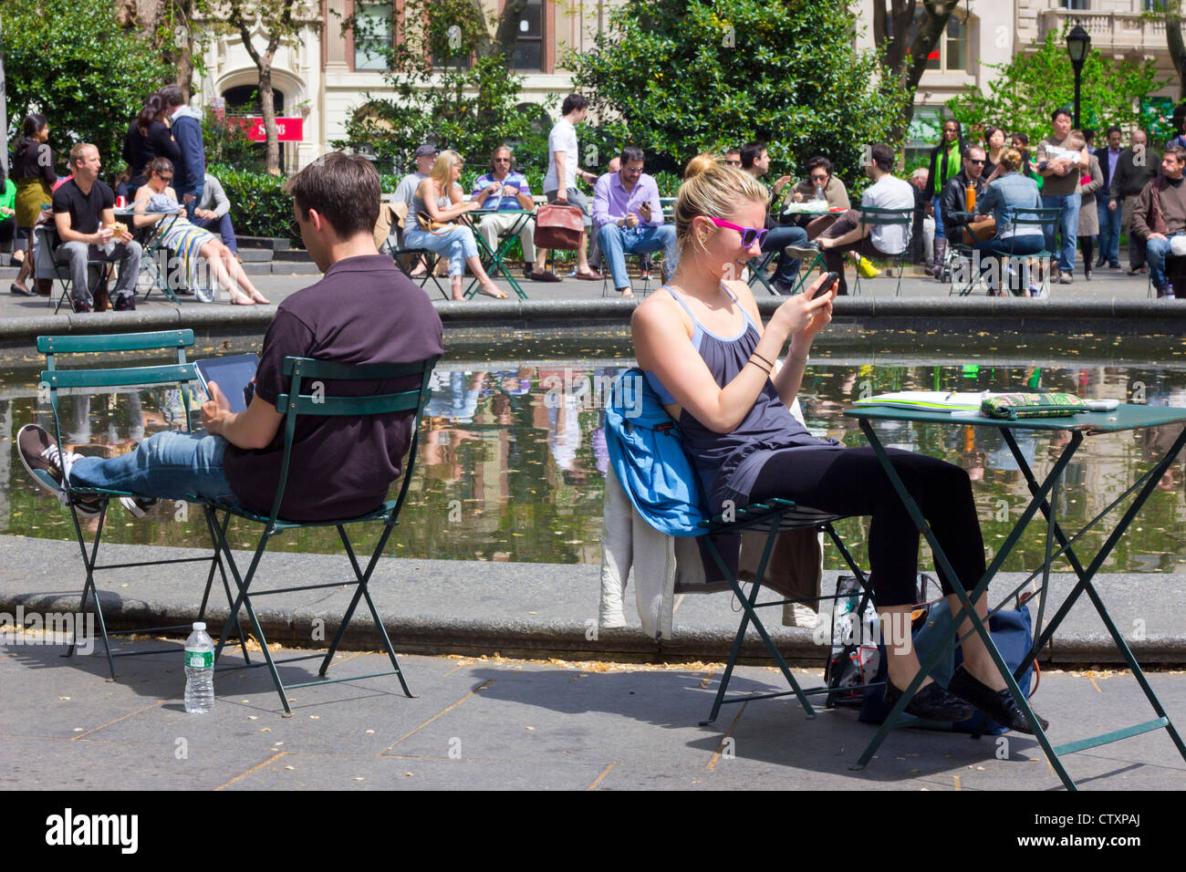 Les gens de Madison Square Park, à New York le jour de printemps sur les appareils électroniques Banque D'Images