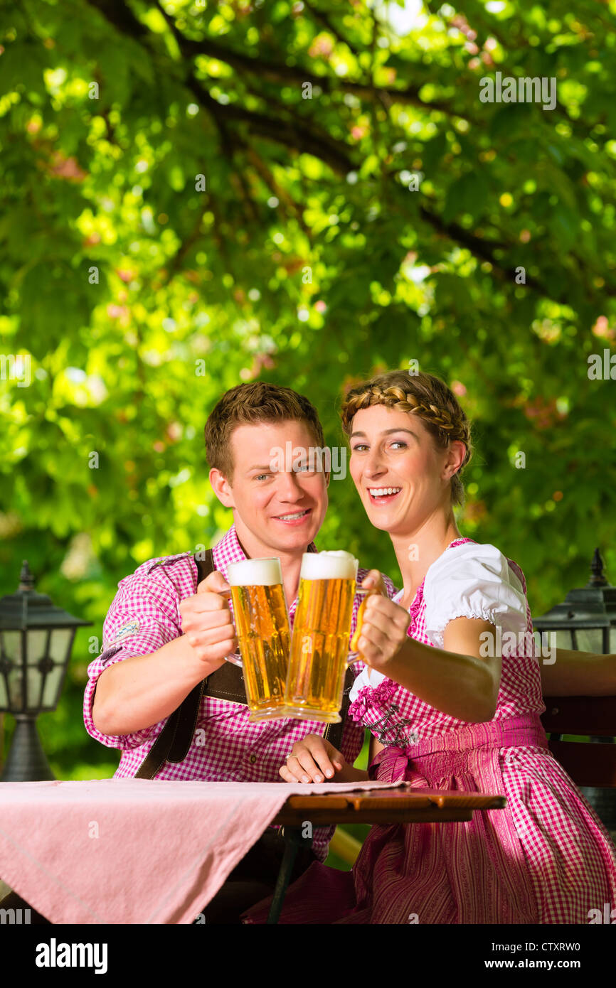 Heureux couple assis dans un café en plein air en été et prendre un verre de bière et le soleil Banque D'Images