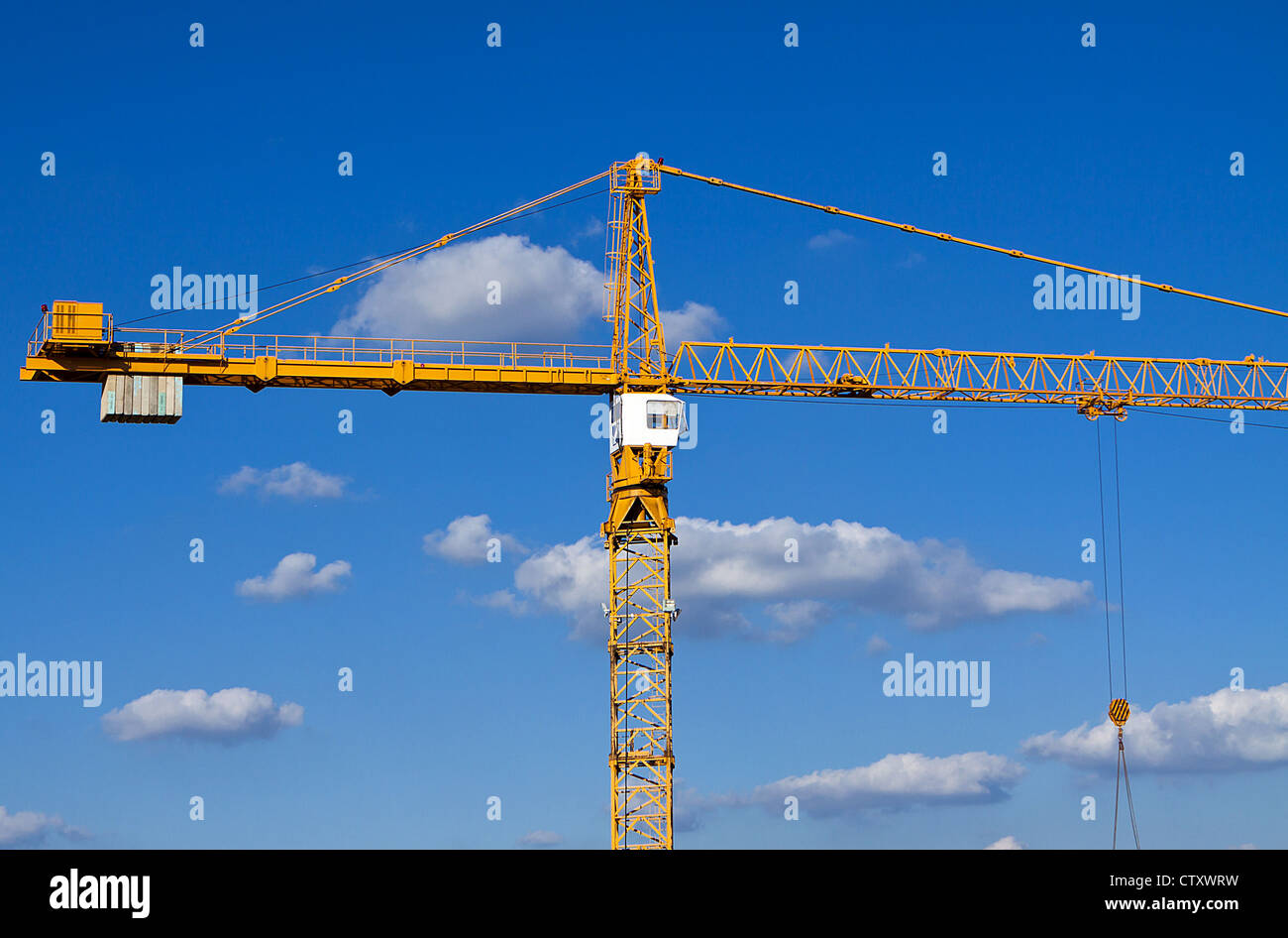 Grue de construction contre un ciel bleu avec fond de nuage. Banque D'Images