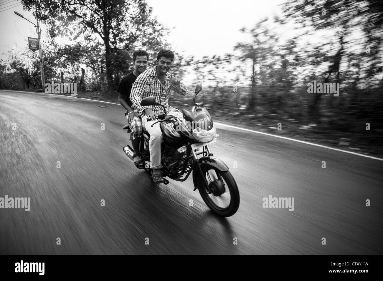 Deux résidents Khandala équitation une moto après une des premières pluies de mousson de cette saison. Banque D'Images