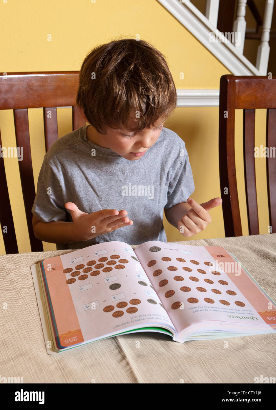 7 ans d'âge scolaire élémentaire mexico-garçon ne devoirs de mathématiques à l'aide de doigts pour compter à la maison Banque D'Images