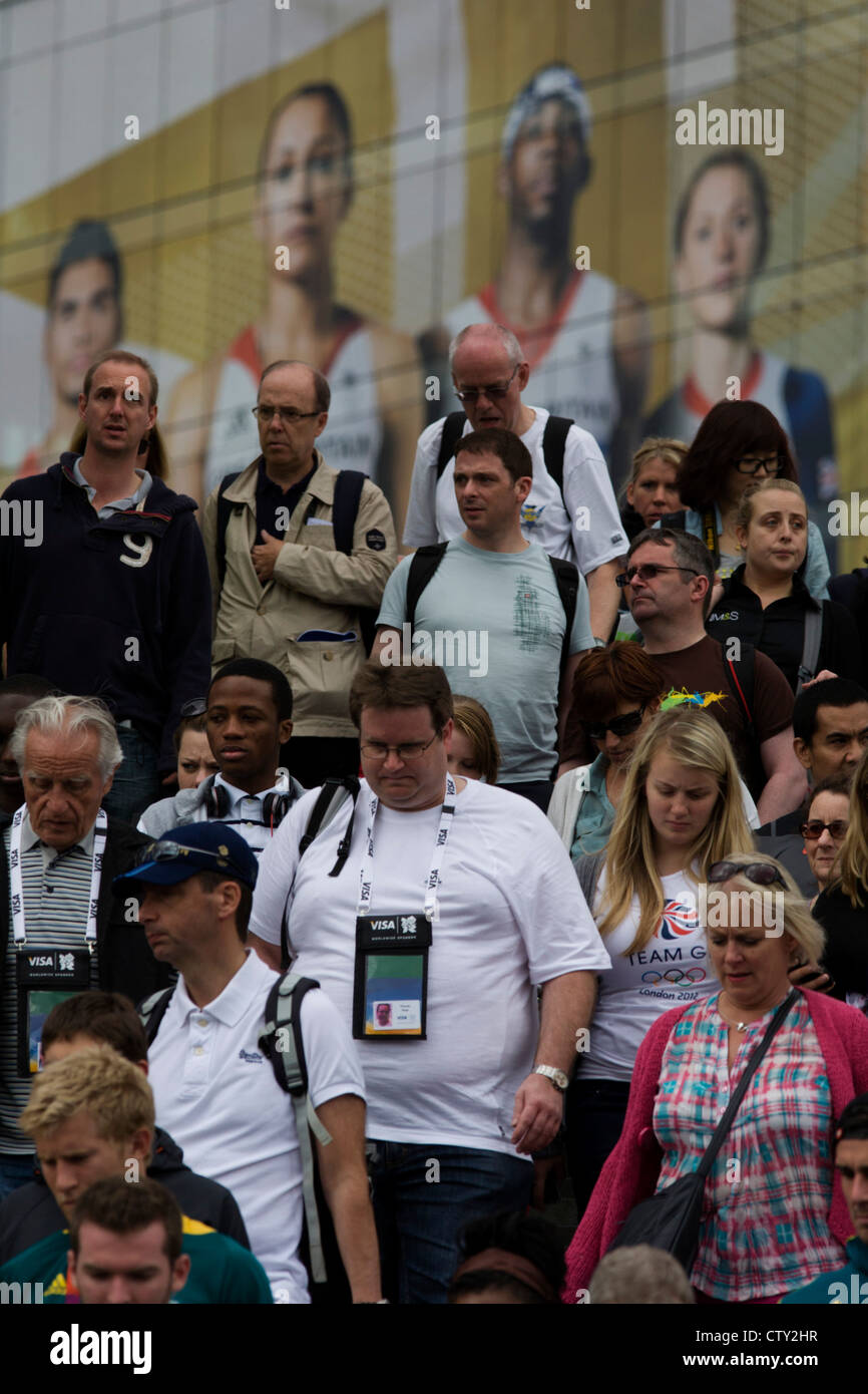 Géant avec présence de l'équipe Go modèle de rôle héros sportif derrière eux, la foule des spectateurs descendre des marches au Westfield Stratford City Shopping Complex, qui mène au Parc olympique au cours de l'Jeux olympiques de 2012 à Londres, la 30e Olympiade. L'annonce est pour la marque de chaussures de sport Adidas et leur 'la scène' campagne y compris diver Tom Daley, gymnaste Louis Smith, cavalier de Phillips Idowu et le chouchou de la athlétisme, heptathlete d'or olympique Jessica Ennis. Banque D'Images