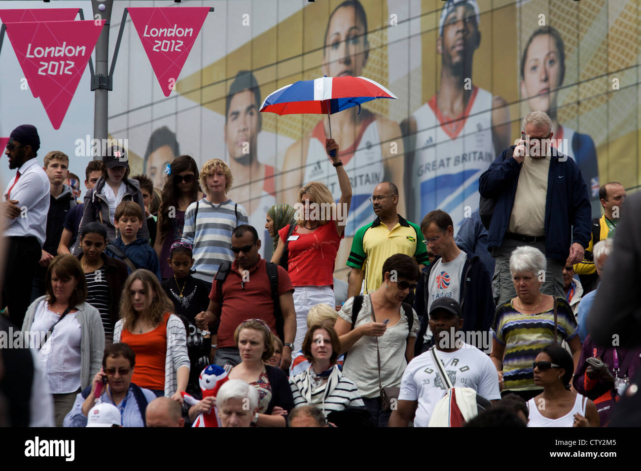 Géant avec présence de l'équipe Go modèle de rôle héros sportif derrière eux, la foule des spectateurs descendre des marches au Westfield Stratford City Shopping Complex, qui mène au Parc olympique au cours de l'Jeux olympiques de 2012 à Londres, la 30e Olympiade. L'annonce est pour la marque de chaussures de sport Adidas et leur 'la scène' campagne y compris diver Tom Daley, gymnaste Louis Smith, cavalier de Phillips Idowu et le chouchou de la athlétisme, heptathlete d'or olympique Jessica Ennis. Banque D'Images