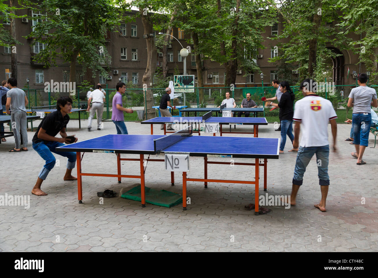 Les jeunes à jouer au tennis de table sur les tables en plein air à Douchanbé, Tadjikistan Banque D'Images