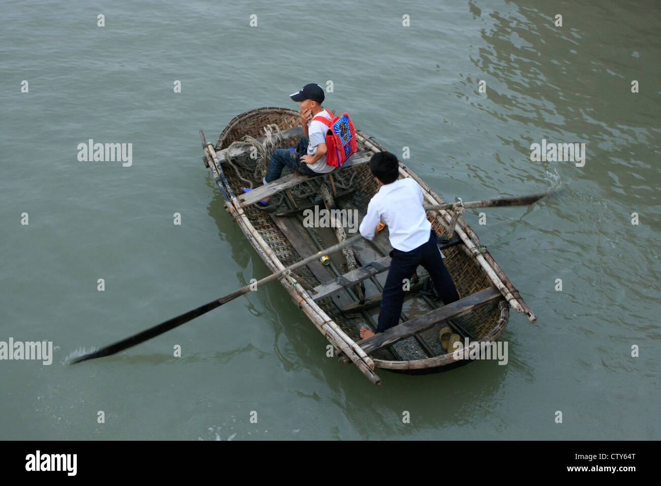 Les garçons en bateau traditionnel vietnamien, Halong Bay, Vietnam Banque D'Images