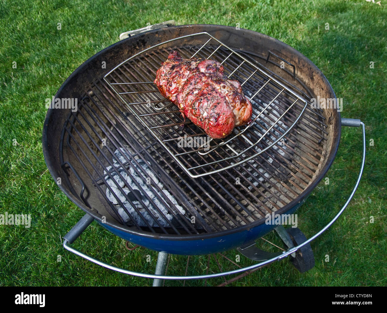Gigot d'agneau désossé assaisonnée sur barbecue au charbon à l'aide d'un  rack de torréfaction Photo Stock - Alamy
