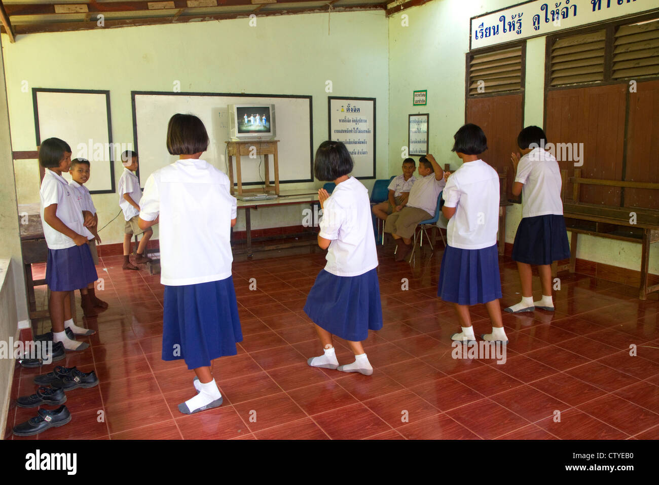 Les élèves du primaire thaï danse avec les directives d'un téléviseur à l'école sur l'île de Ko Samui, Thaïlande. Banque D'Images