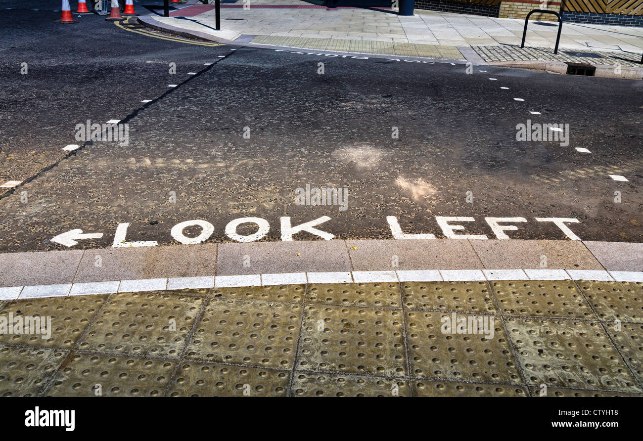 Look 'Gauche', signe sur le bord de la route indiquant la sécurité des piétons Banque D'Images