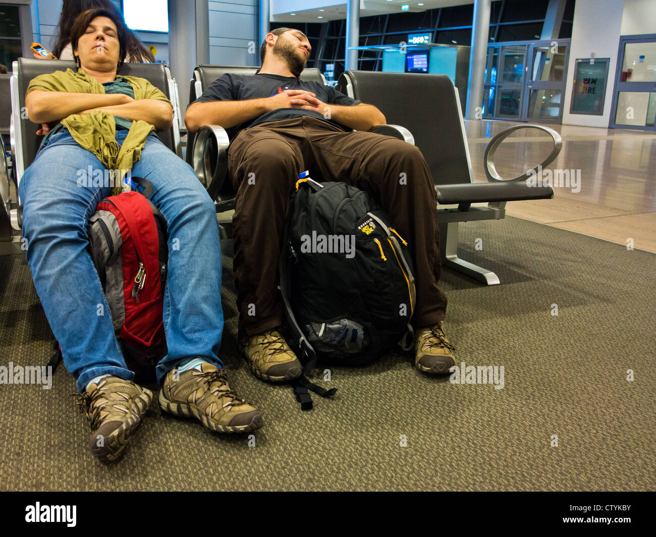 Voyageurs fatigués s'endormir sur des chaises à l'aéroport international Ben Gourion de Tel-Aviv. Banque D'Images