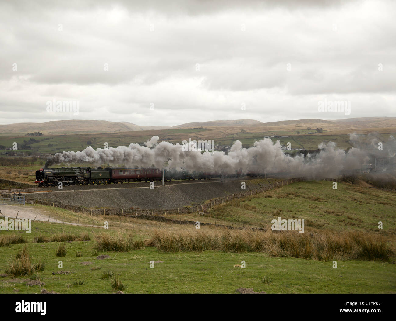 Locomotive vapeur 70013 'Oliver Cromwell' prend une montagne de Cumbrie Express train sur Shap à Greenholme, Cumbria, Angleterre. Banque D'Images