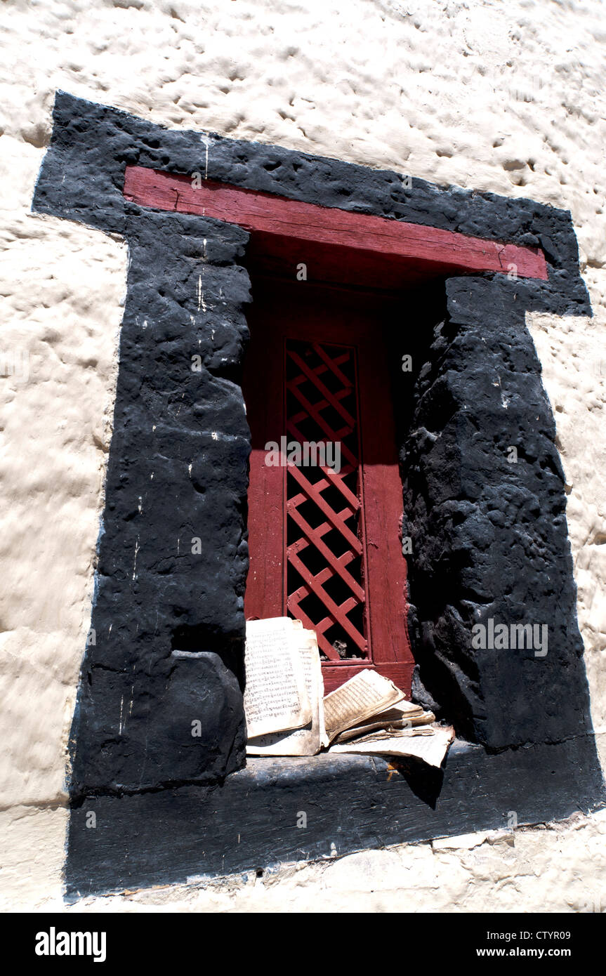 Noir et rouge fenêtre contre un mur blanc avec un livre sur la corniche au Palais Stok, Stok, Ladakh, Inde Banque D'Images