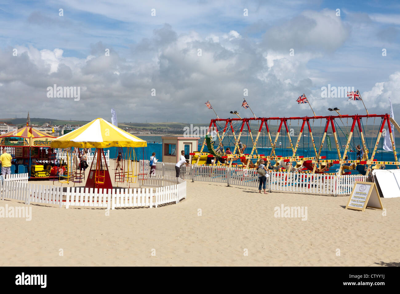 Les manèges forains sur plage de Weymouth, dans le Dorset Banque D'Images