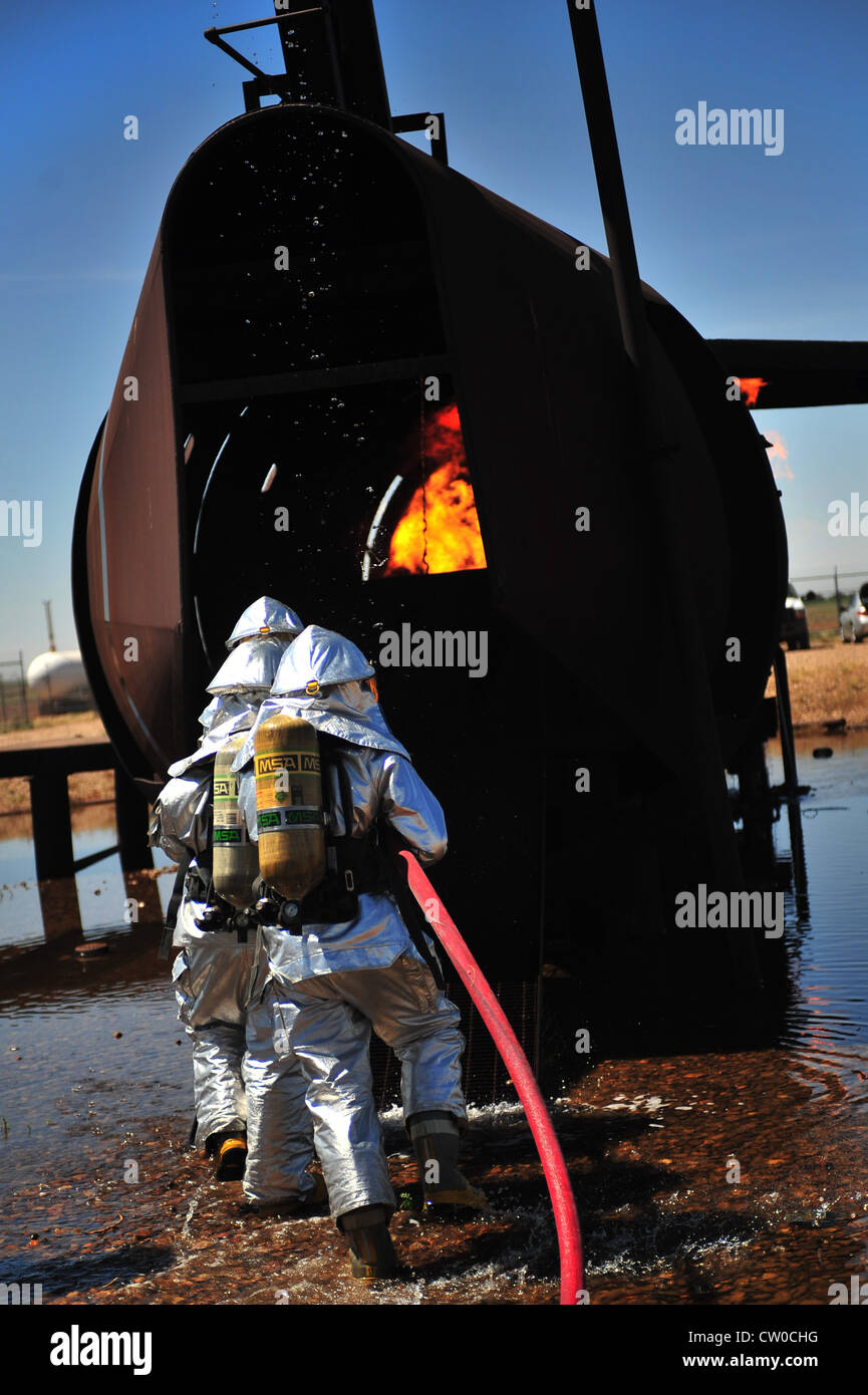 Les pompiers du 2e Escadron du génie civil des opérations spéciales entrent dans la fosse à combustion de la base aérienne de Cannon, N.M., le 2 août 2012. La fosse abrite un avion répliqué équipé d'un réservoir de propane et de plusieurs allumeurs utilisés pour soutenir les incendies d'entraînement. Banque D'Images