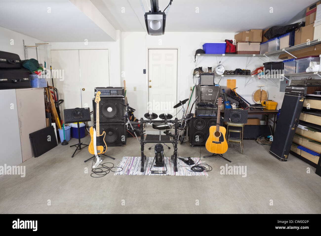 Des équipements de musique rock band dans un garage de banlieue encombrée. Banque D'Images