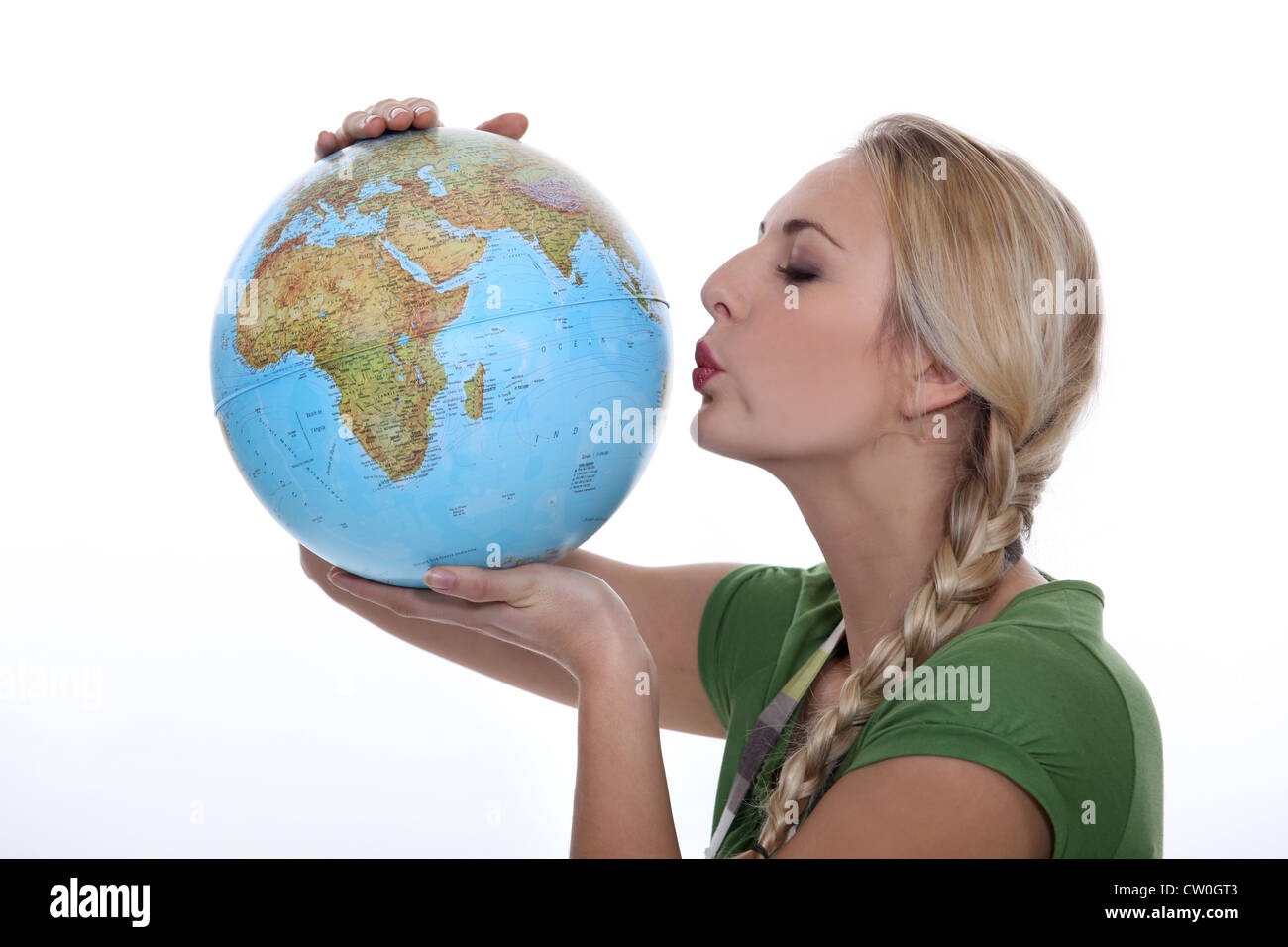 Femme dans un haut vert embrassant un globe Banque D'Images