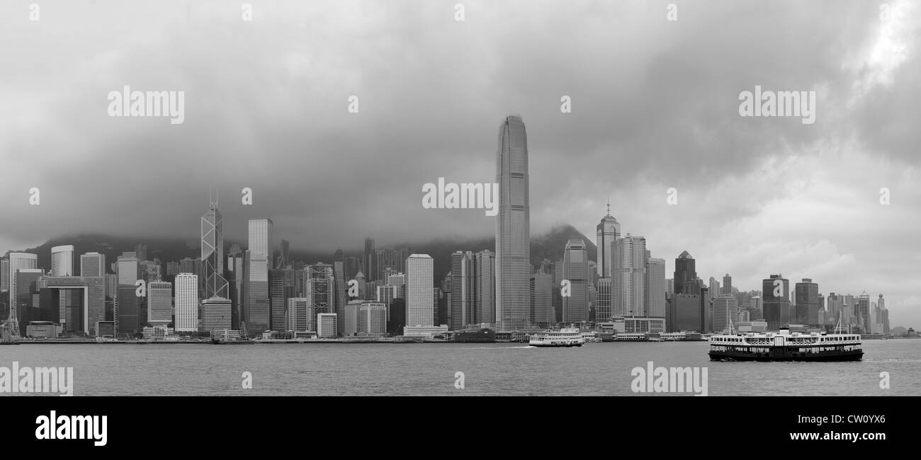 Architecture urbaine dans le port de Victoria de Hong Kong avec des toits et nuage dans la journée en noir et blanc. Banque D'Images