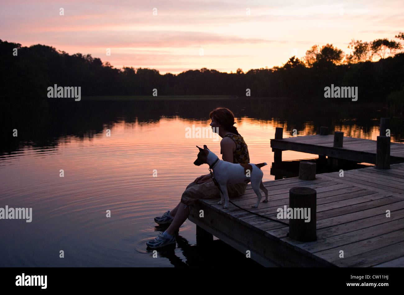 Jeune femme assise avec son chien sur un quai sur le lac à la Mount Saint Francis dans Floyd Comté (Indiana) Banque D'Images