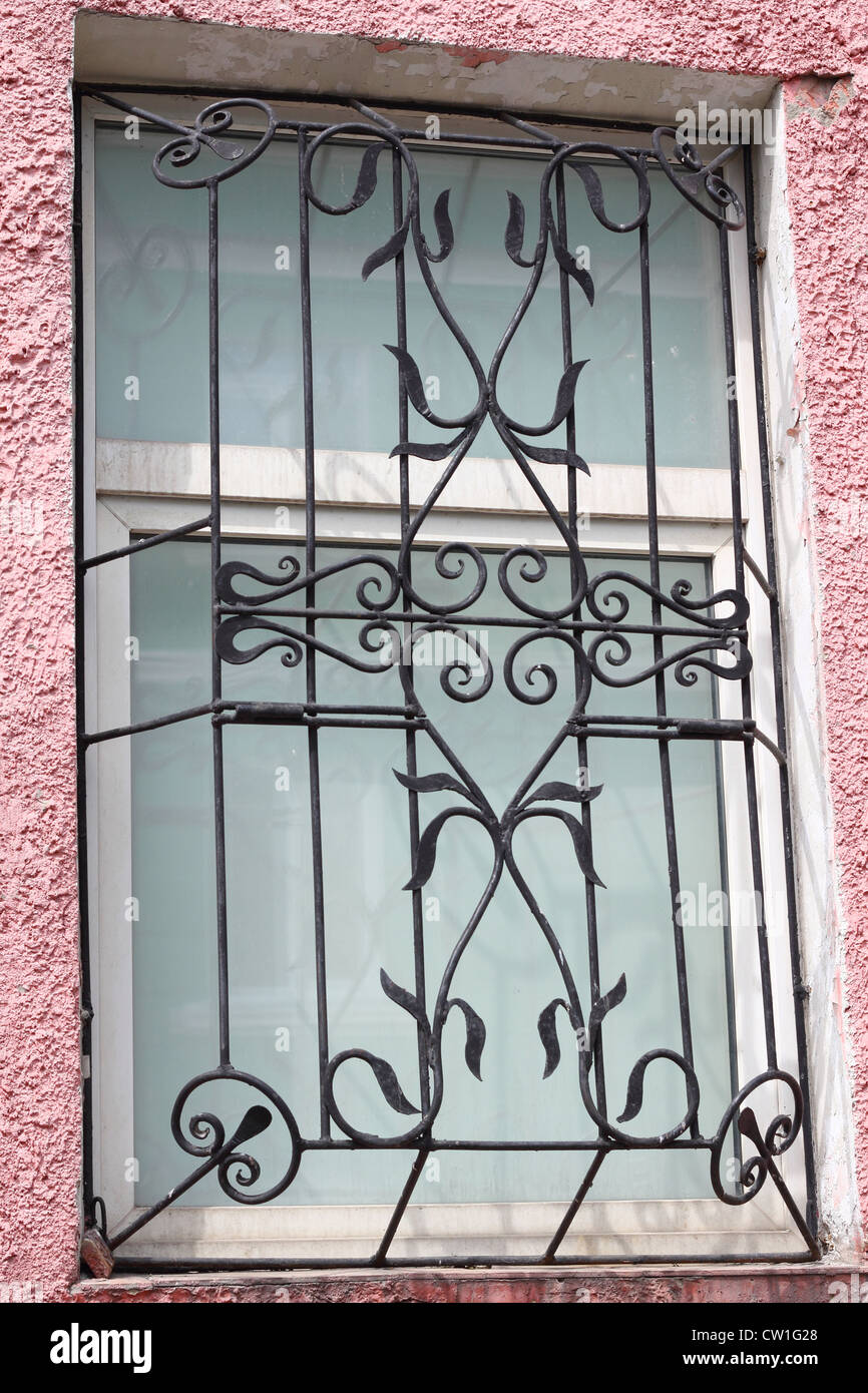 Black metal faux treillis sculptés lors d'une fenêtre en plastique blanc Banque D'Images