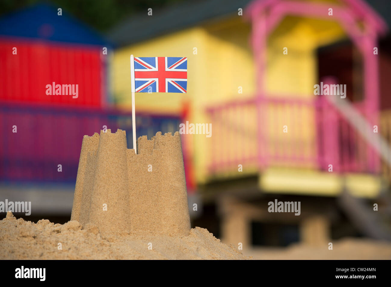 Union Jack flag dans un château de sable en face de cabines colorées. Wells next the sea. Norfolk, Angleterre Banque D'Images