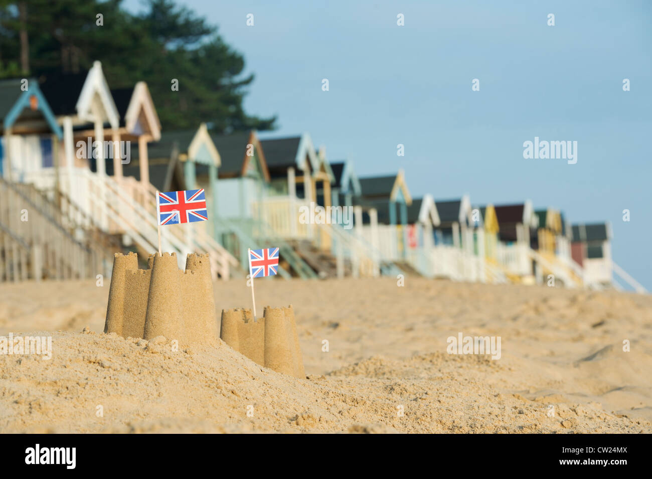 Drapeaux Union Jack dans des châteaux de sable en face de cabines de plage. Wells next the sea. Norfolk, Angleterre Banque D'Images