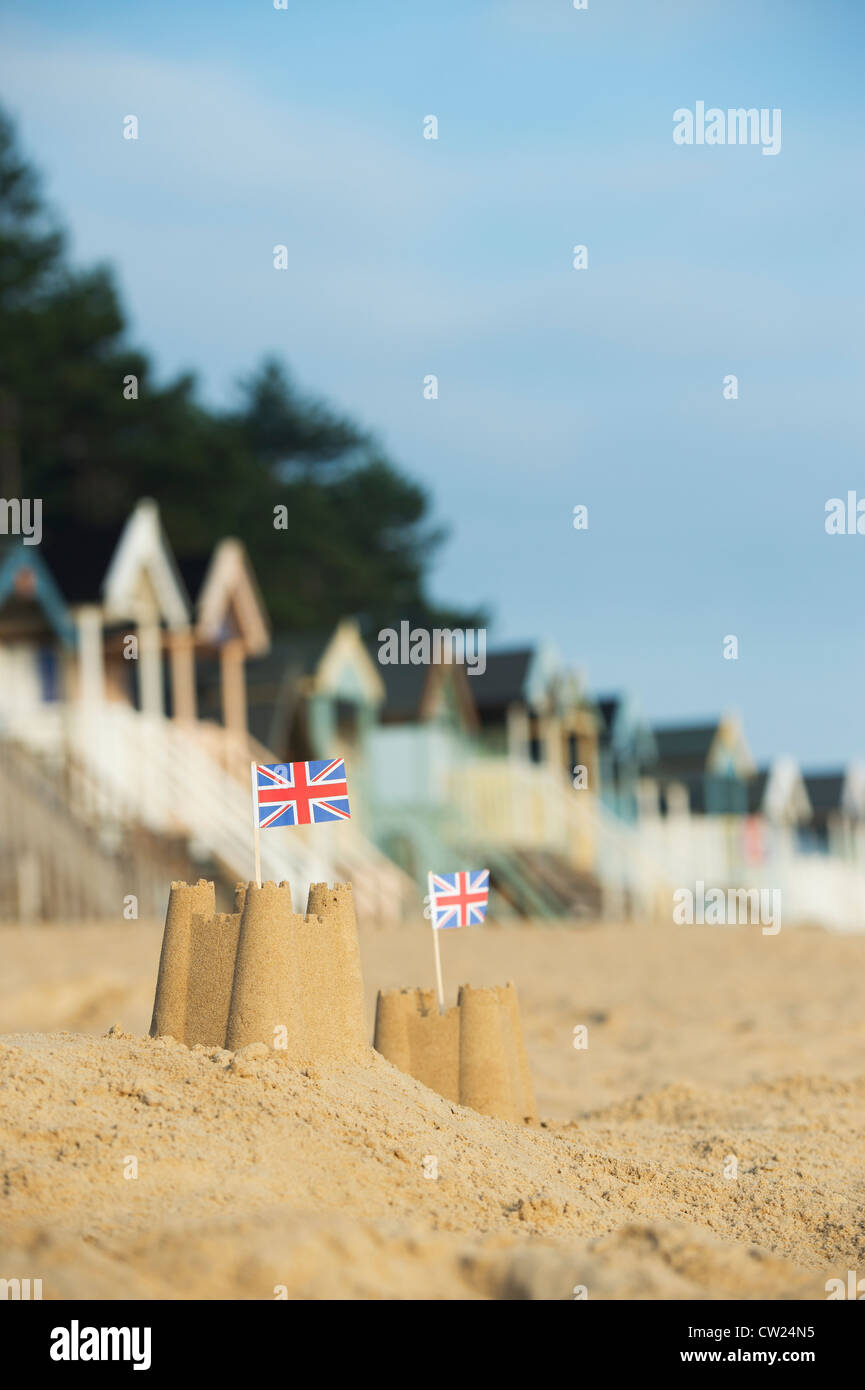 Drapeaux Union Jack dans des châteaux de sable en face de cabines de plage. Wells next the sea. Norfolk, Angleterre Banque D'Images