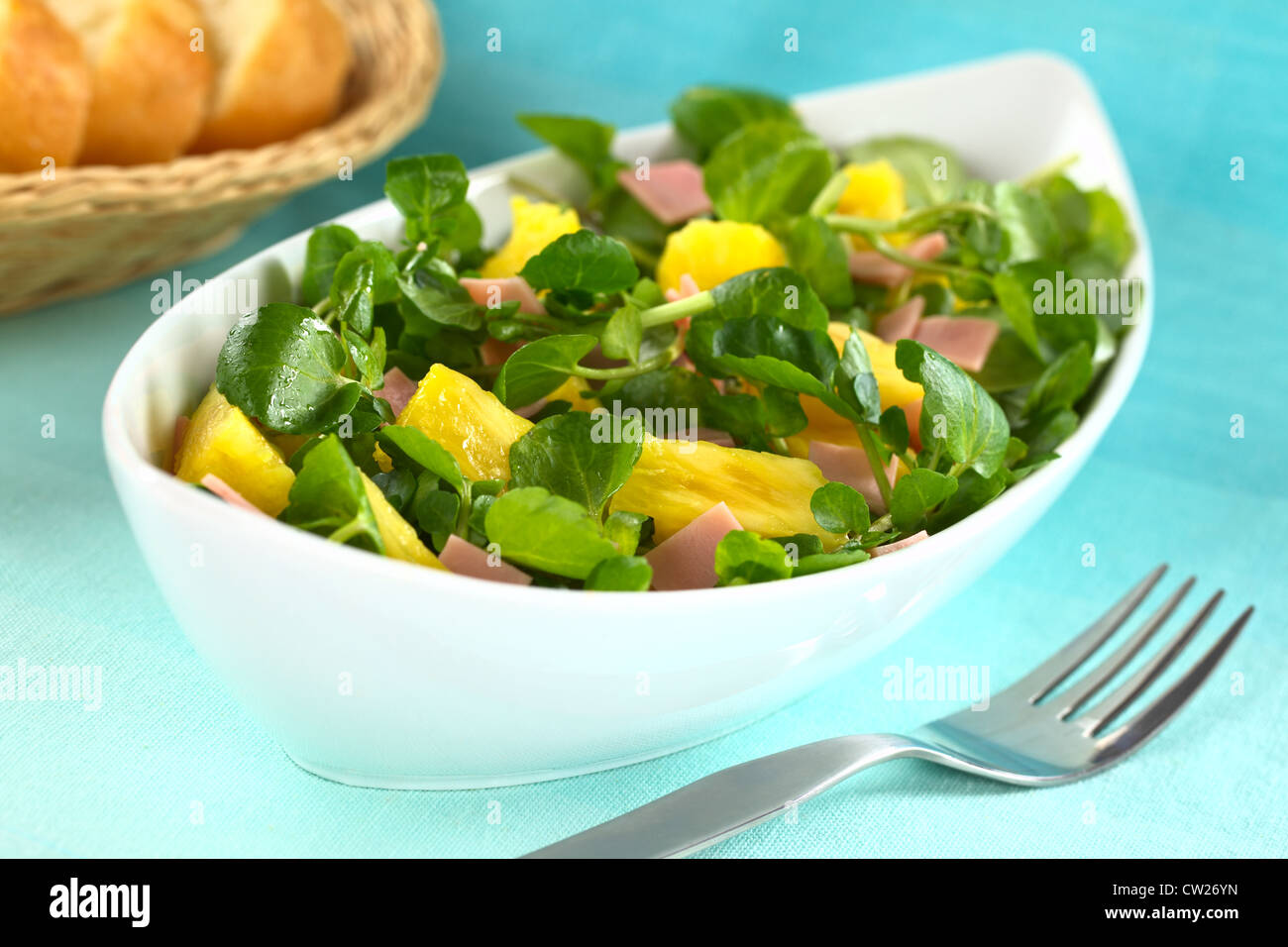 Le cresson frais, ananas et salade de jambon blanc allongé en bol avec tranches de baguette à l'arrière Banque D'Images