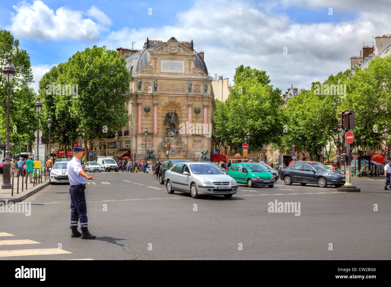 Réglemente le trafic au niveau policier Place Saint-Michel place publique en face d'une fontaine monumentale à Paris, France. Banque D'Images
