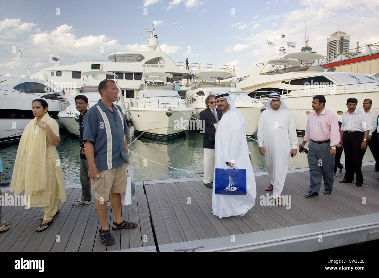 Dubaï, un groupe d'hommes arabes en face de yachts de luxe marina Banque D'Images