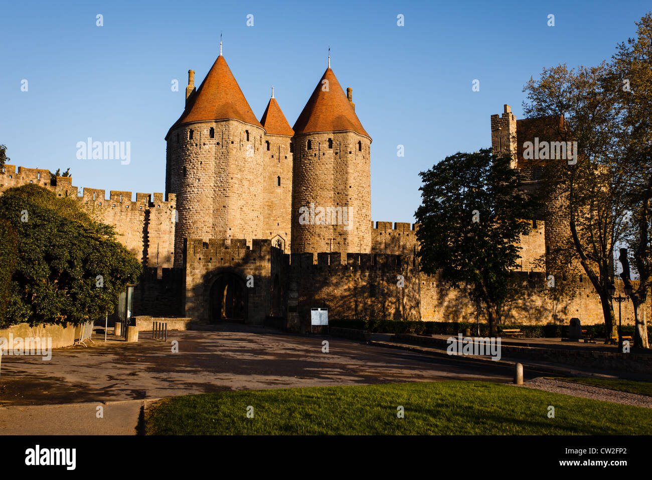 Remparts et entrée au Château Comtal tours avec soleil sur leurs toits de tuiles rouges dans la cité médiévale de Carcassonne, France. Banque D'Images