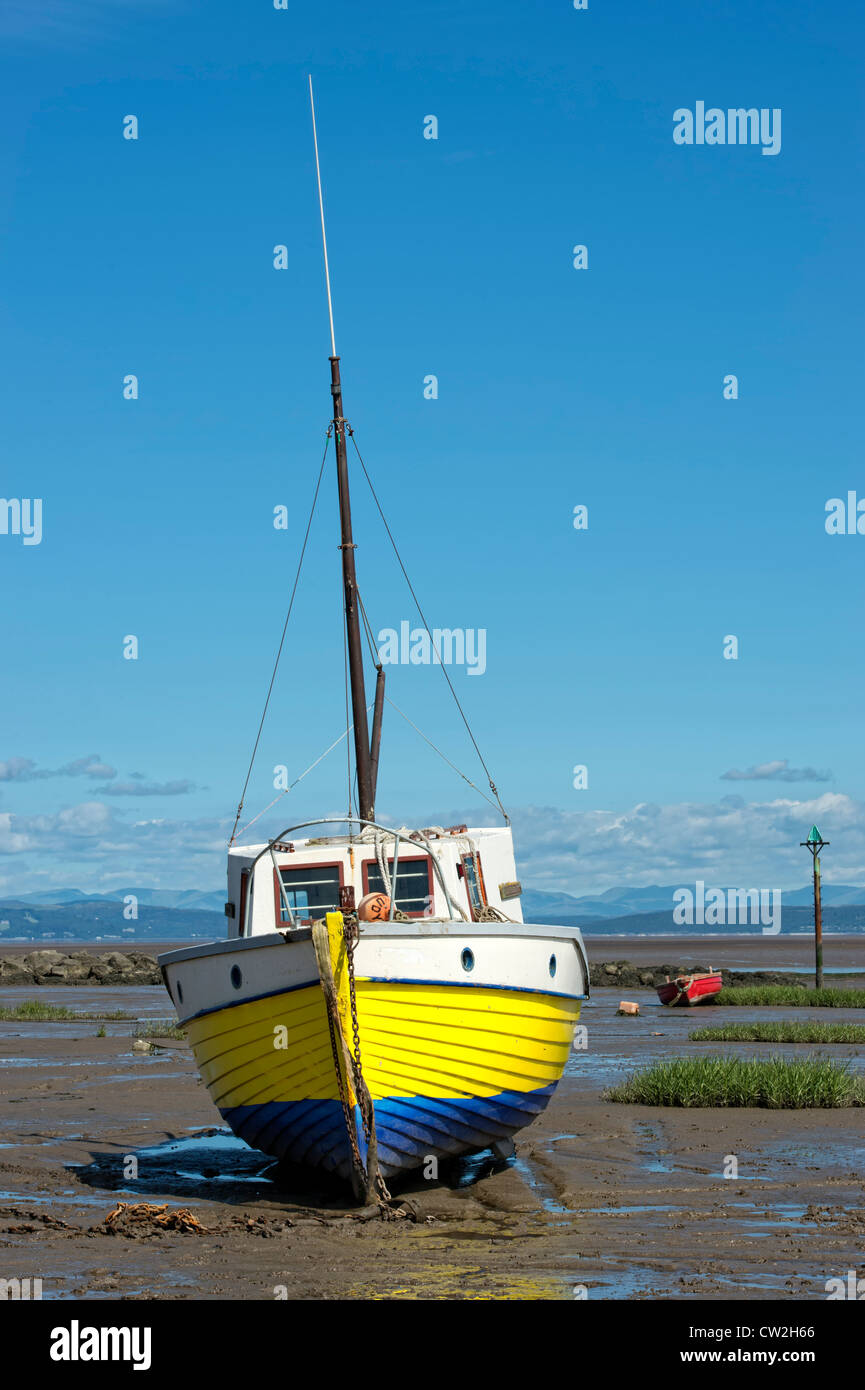 Bateau de pêche en bois jaune garé par la marée dans la baie de Morecambe, Lancashire Banque D'Images