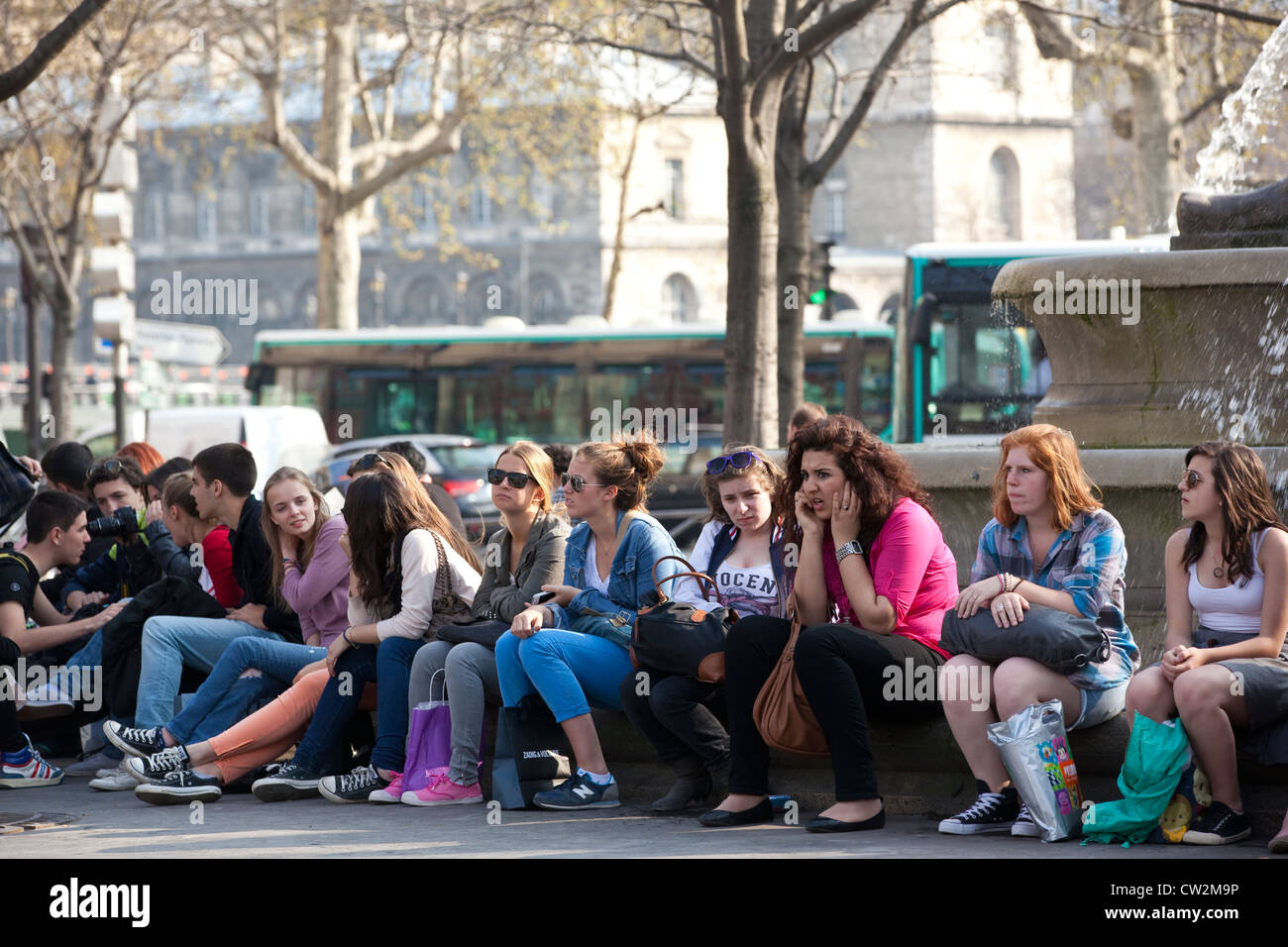 Les étudiants français s'asseoir sous le La Fontaine du palmier à la place du Châtelet, Paris, France. Banque D'Images