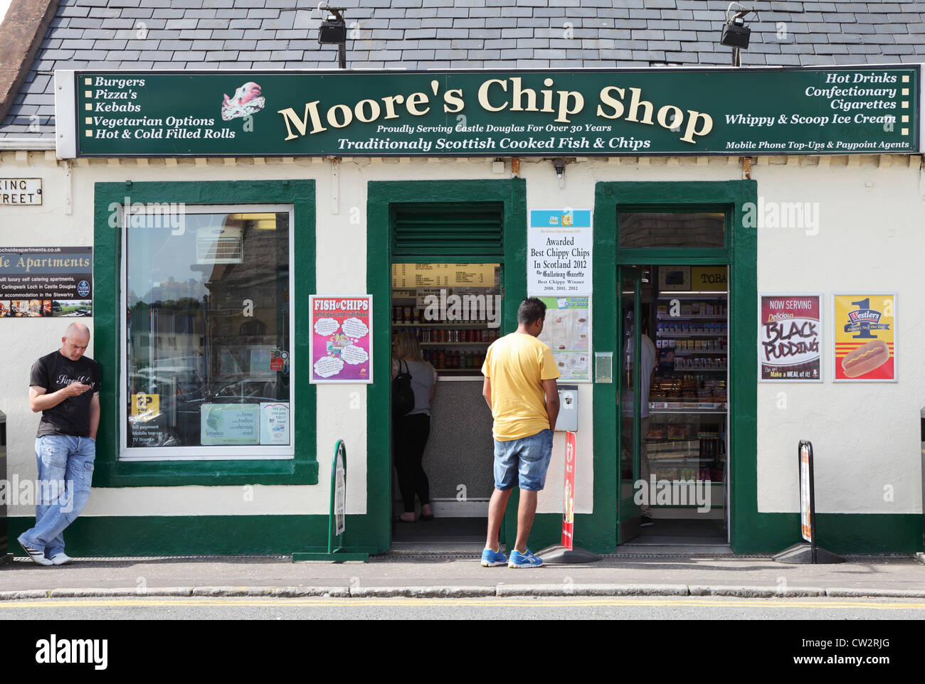 Hommes debout à l'extérieur de Moore Friterie, Castle Douglas, au sud ouest de l'Ecosse UK Banque D'Images